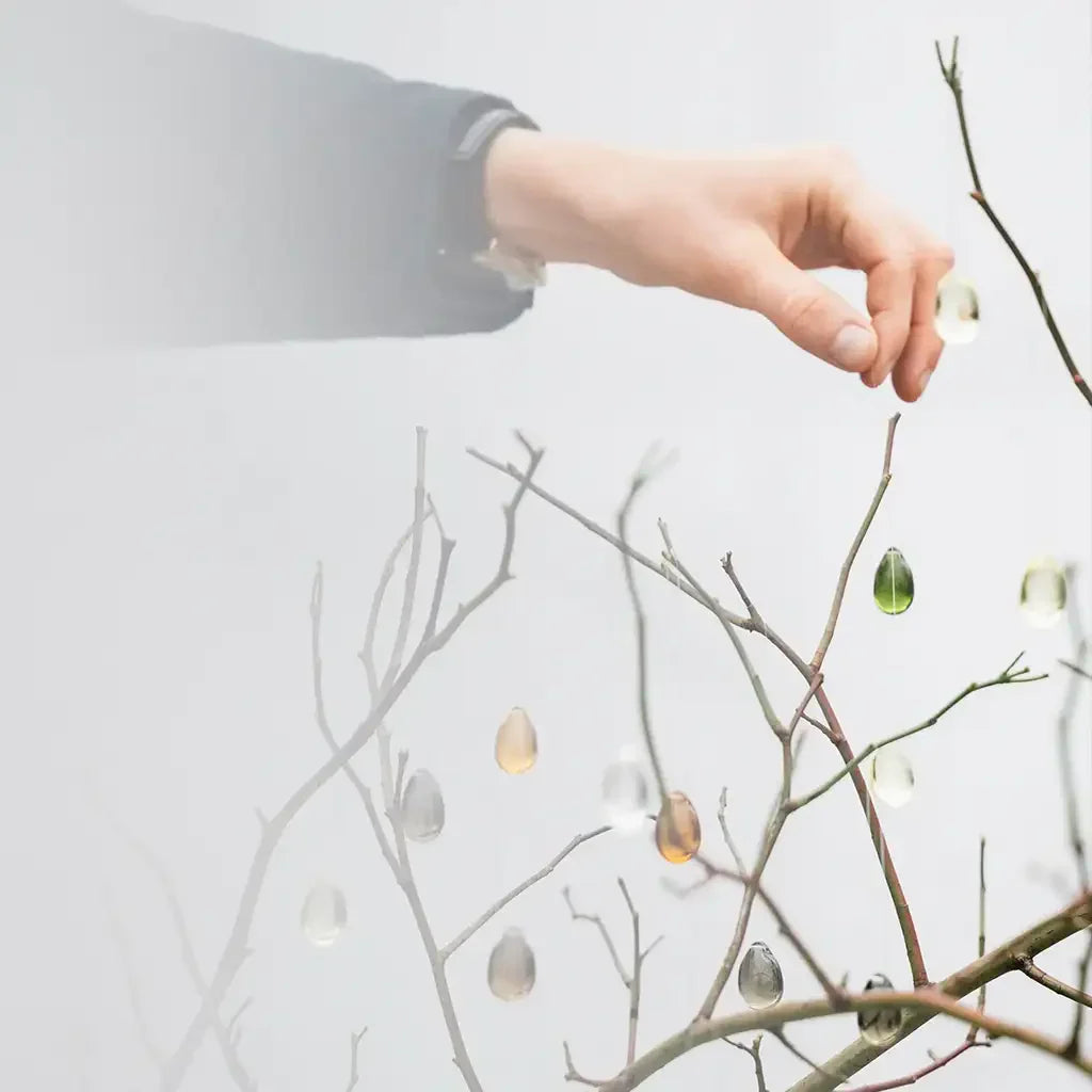 Hängande glasdroppar på grenar